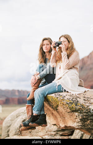 Deux femmes sur un rocher, l'un tenant une caméra. Banque D'Images