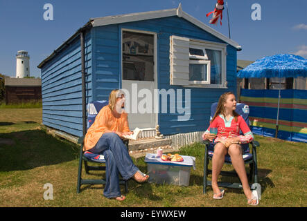 Debbie contremaître et sa fille Maisie avec leurs vacances en bord de plage en bois hut(chalet) dans la région de Portland Bill, Dorset, Royaume-Uni. un Banque D'Images