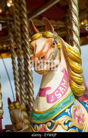 Cheval au galop à vapeur carrousel, fairground ride à un bain à vapeur juste. L'Angleterre Banque D'Images