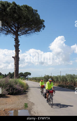 Deux cyclistes de randonnée équestre sur une route de campagne dans la région de Pouilles, Italie Banque D'Images