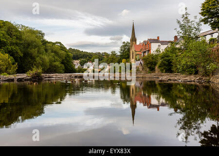 La réflexion de Llangollen dans la rivière Dee sur un ton calme, chaude soirée d'été. Banque D'Images