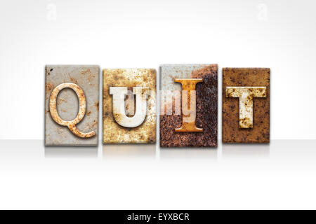 Le mot 'QUITTER' écrit en métal rouillé type typographique isolé sur un fond blanc. Banque D'Images