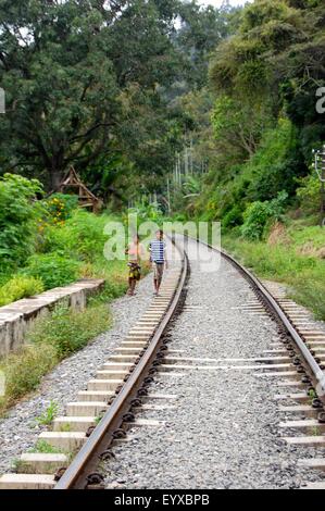 Deux garçons marcher le long d'une voie ferrée près de Ella au Sri Lanka Banque D'Images