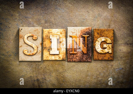 Le mot 'SING' écrit en métal rouillé type typographique sur un vieux fond vieux cuir. Banque D'Images