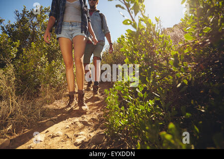 Les randonneurs à pied par-pays. Deux jeunes randonnées sur les montagnes sur la journée ensoleillée. Cropped shot l'accent sur les jambes. Banque D'Images