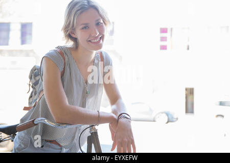 Portrait smiling woman on bicycle Banque D'Images