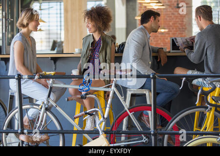 Amis de parler et de boire du café au café patio avec des bicyclettes Banque D'Images