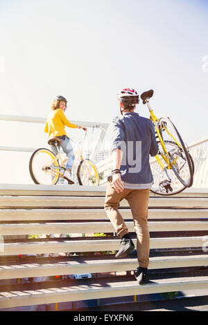 L'homme dans l'exécution de casque vélo urbain d'escaliers Banque D'Images