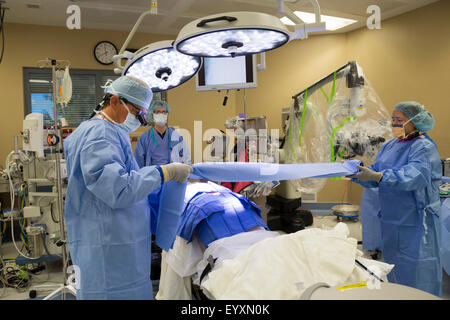 Englewood, Colorado - Le Dr Paul Elliott (à gauche) et son équipe chirurgicale se préparent à effectuer une chirurgie lombaire. Banque D'Images