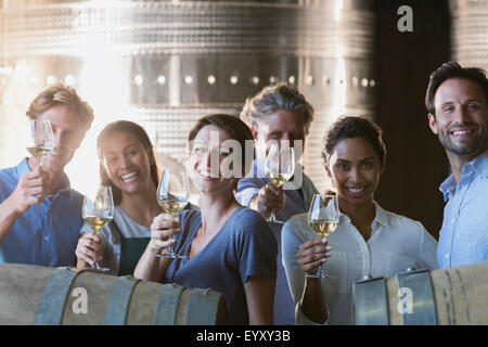 Portrait of smiling friends la dégustation de vins en cave de vinification Banque D'Images