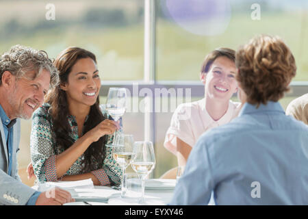 Les amis de boire du vin et de parler à table de restaurant Banque D'Images