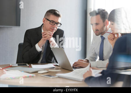 Les gens d'affaires travaillant à l'ordinateur portable dans la salle de conférence réunion Banque D'Images