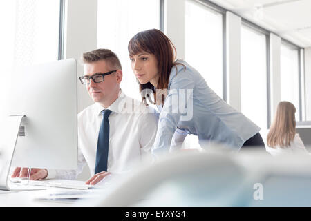 L'accent businessman and businesswoman working at computer in office Banque D'Images