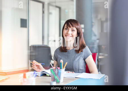 Portrait confiant brunette businesswoman working in conference room Banque D'Images