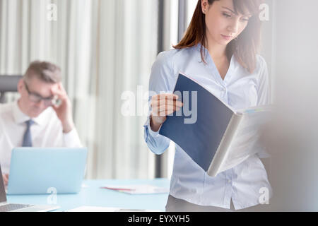 L'accent businesswoman reading report in office Banque D'Images