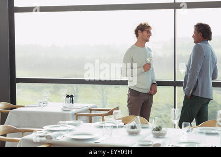 Les hommes de boire du vin au restaurant window Banque D'Images