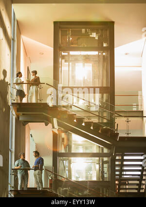 Vintners debout sur plates-formes dans sunny winery Banque D'Images