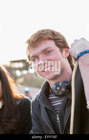 Teenage boy holding skateboard en plein air Banque D'Images