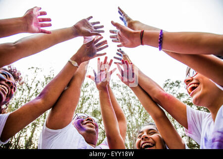 Low angle view of friends couvert de poudre de pigment cheering Banque D'Images