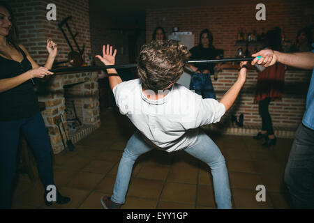 Les amis de la danse limbo in nightclub Banque D'Images