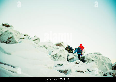 Caucasian hiker escalade rochers enneigés Banque D'Images