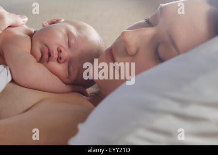 Mère dormir avec bébé nouveau-né on bed Banque D'Images