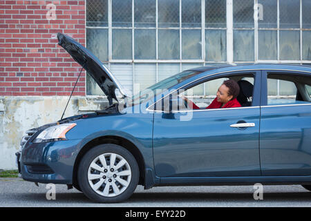 Black woman with broken down car Banque D'Images