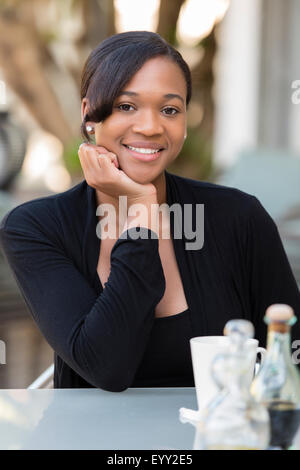 Mixed Race businesswoman smiling at outdoor cafe Banque D'Images