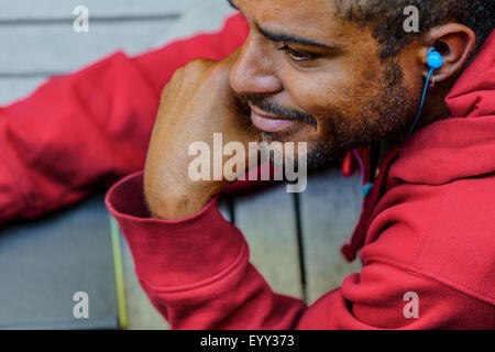 Close up of mixed race man listening to oreillette Banque D'Images