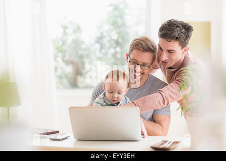 Les pères gays caucasienne et baby using laptop Banque D'Images