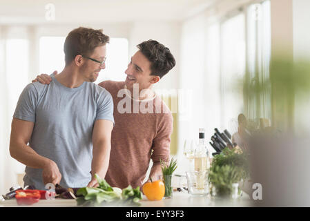 Caucasian couple gay cooking in kitchen Banque D'Images