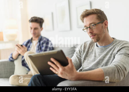 Young gay couple relaxing on sofa Banque D'Images