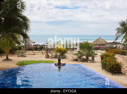 Hispanic woman relaxing in swimming pool Banque D'Images