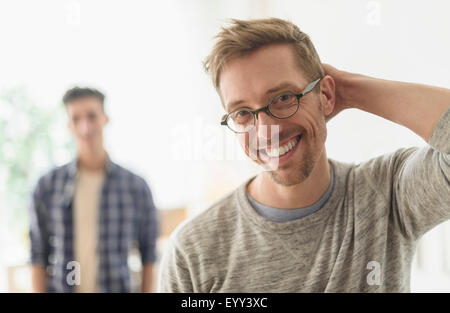 Young gay couple smiling in home Banque D'Images