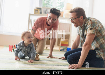 Les pères gays caucasienne et bébé jouant dans la salle de séjour Banque D'Images