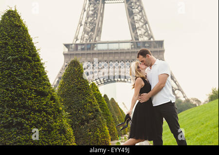 Caucasian couple kissing près de Eiffel Tower, Paris, Ile-de-France, France Banque D'Images