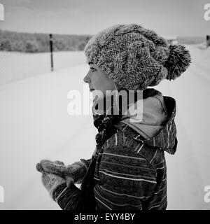 Caucasian girl wearing knit cap et des gants dans la neige Banque D'Images