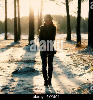 Caucasian woman standing in snowy forest Banque D'Images