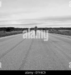 Caucasian Girl standing on vide rural road Banque D'Images