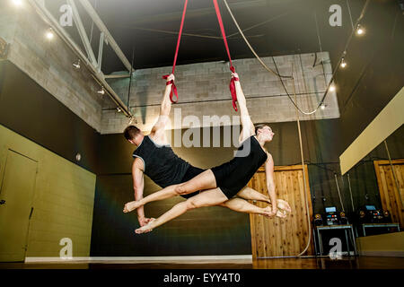 Portrait des acrobates suspendus à des cordes en studio Banque D'Images