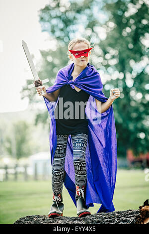 Caucasian girl wearing costume et de jouer à l'épée Banque D'Images