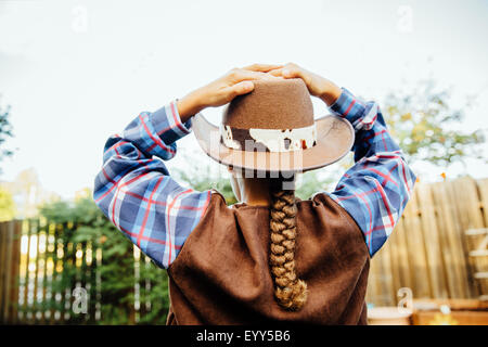 Mixed Race girl wearing cowboy costume en arrière-cour Banque D'Images