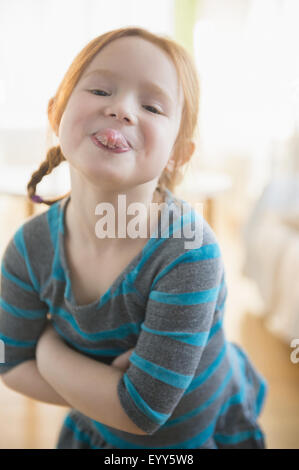 Defiant Caucasian girl sticking out tongue Banque D'Images