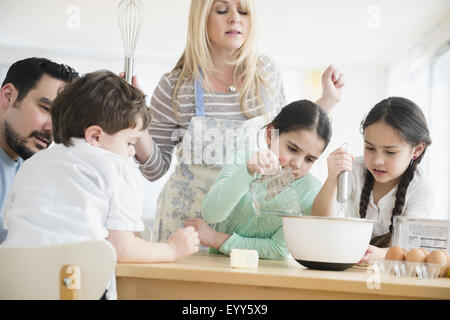 Les parents et les enfants de race blanche dans la cuisine cuisson Banque D'Images