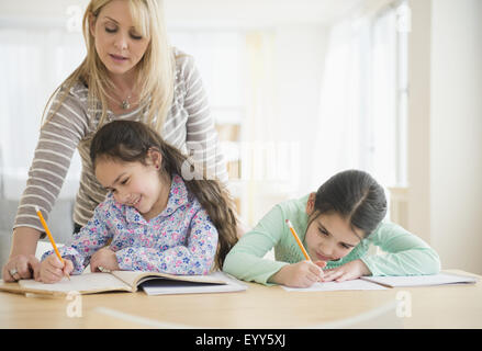 Caucasian mother helping filles faire leurs devoirs Banque D'Images