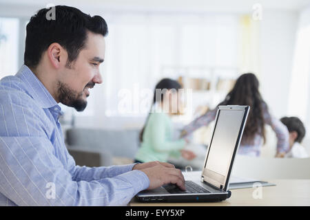 Caucasian man using laptop at desk Banque D'Images