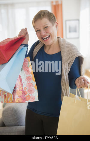 Laughing Caucasian woman holding shopping bags Banque D'Images