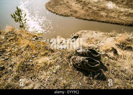 Close up de chaussures abandonnées sur la rivière à distance Banque D'Images