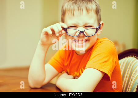 Young boy peering over glasses Banque D'Images