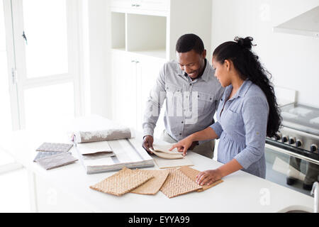 Couple examining fabric swatches in new home Banque D'Images